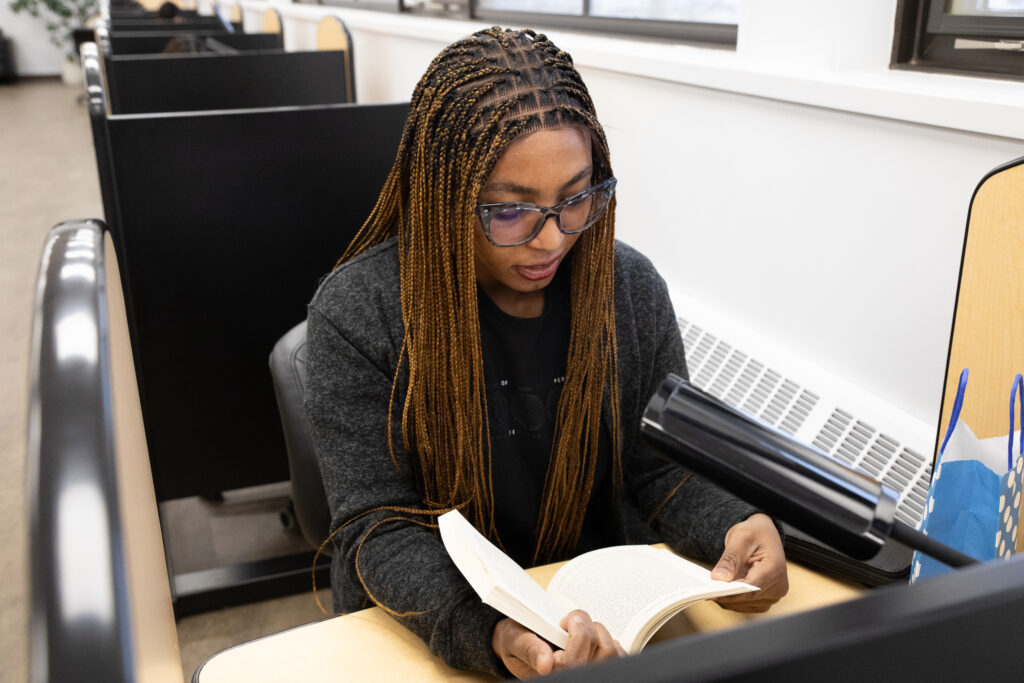 A student sits in the library reading a book