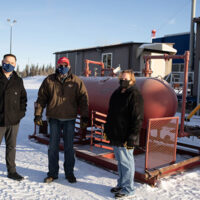 Rodney Cork, Associate Dean of Trades and Apprenticeships; and Elenore Vokes, Oil and Gas Field Operator instructor, stand with Art Jarvis (middle) and the portable gas separator he donated to the NLC simulated wellsite training facility on Jan. 19.