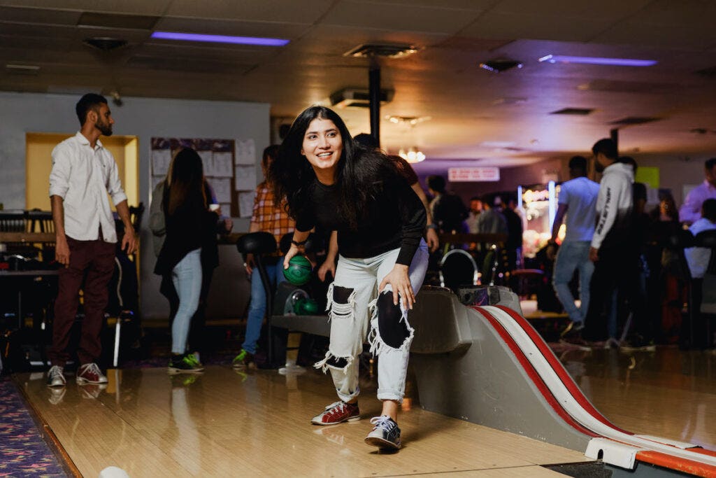 Person throwing a bowling bowl at a bowling lane