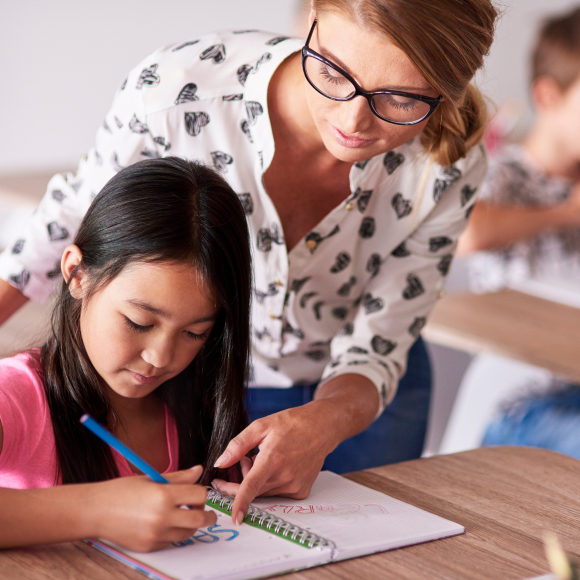 Teacher pointing at young child's notebook