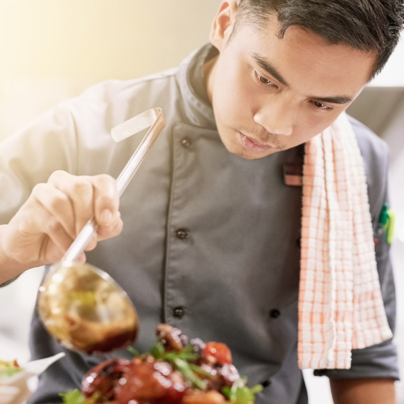 Young chef plating a dish