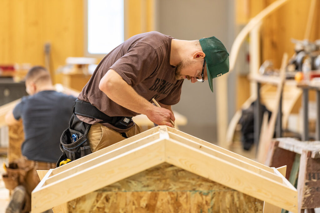 Carpentry student at NLC building a structure