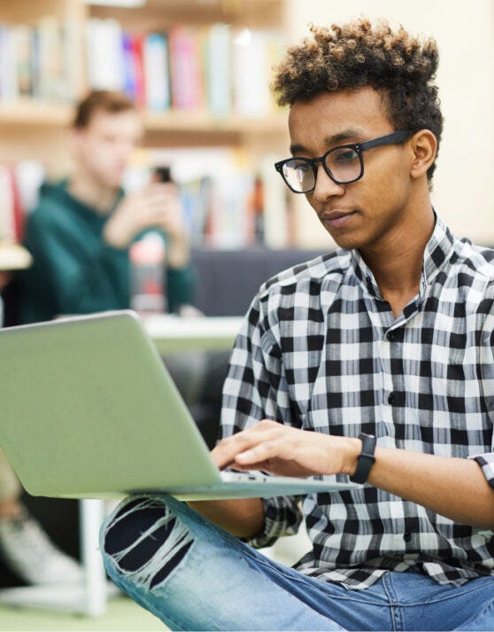 Young man in NLC library working on his laptop