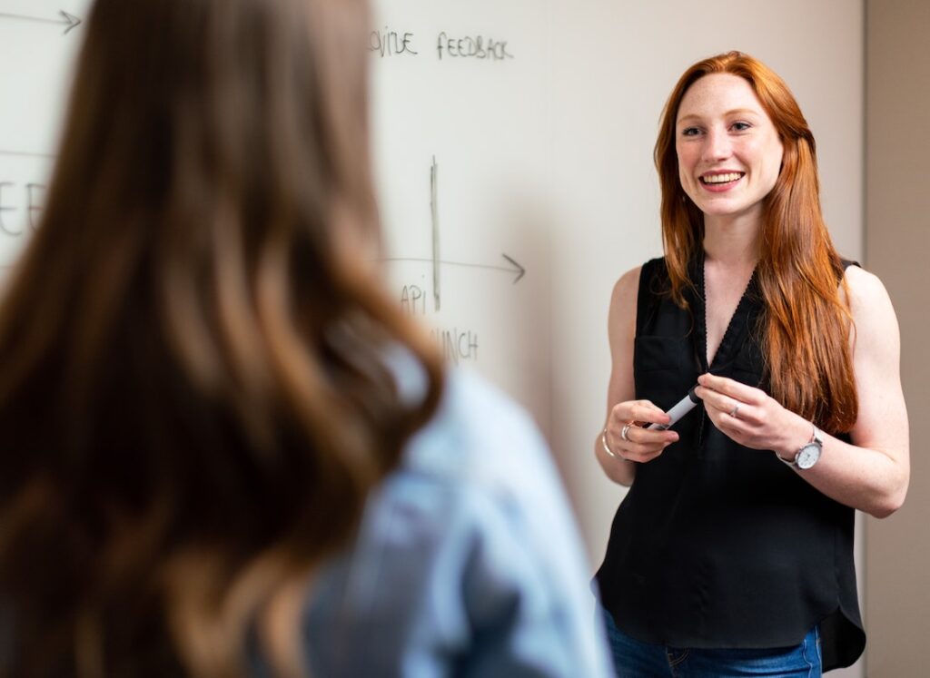 Young teacher smiling at student