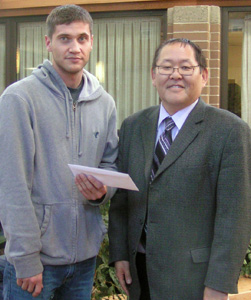 Cody Henderson receiving his award from Vice President Academic and Research Peter Nunoda.